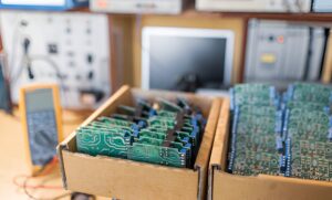Boxes of electronic circuit boards in a warehouse or lab setting, representing the need for specialized 3PL logistics for fragile and high-value electronics